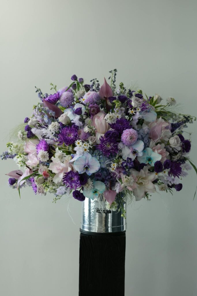 Beautiful bouquet featuring purple and pastel flowers in a sleek vase. Perfect for decor.